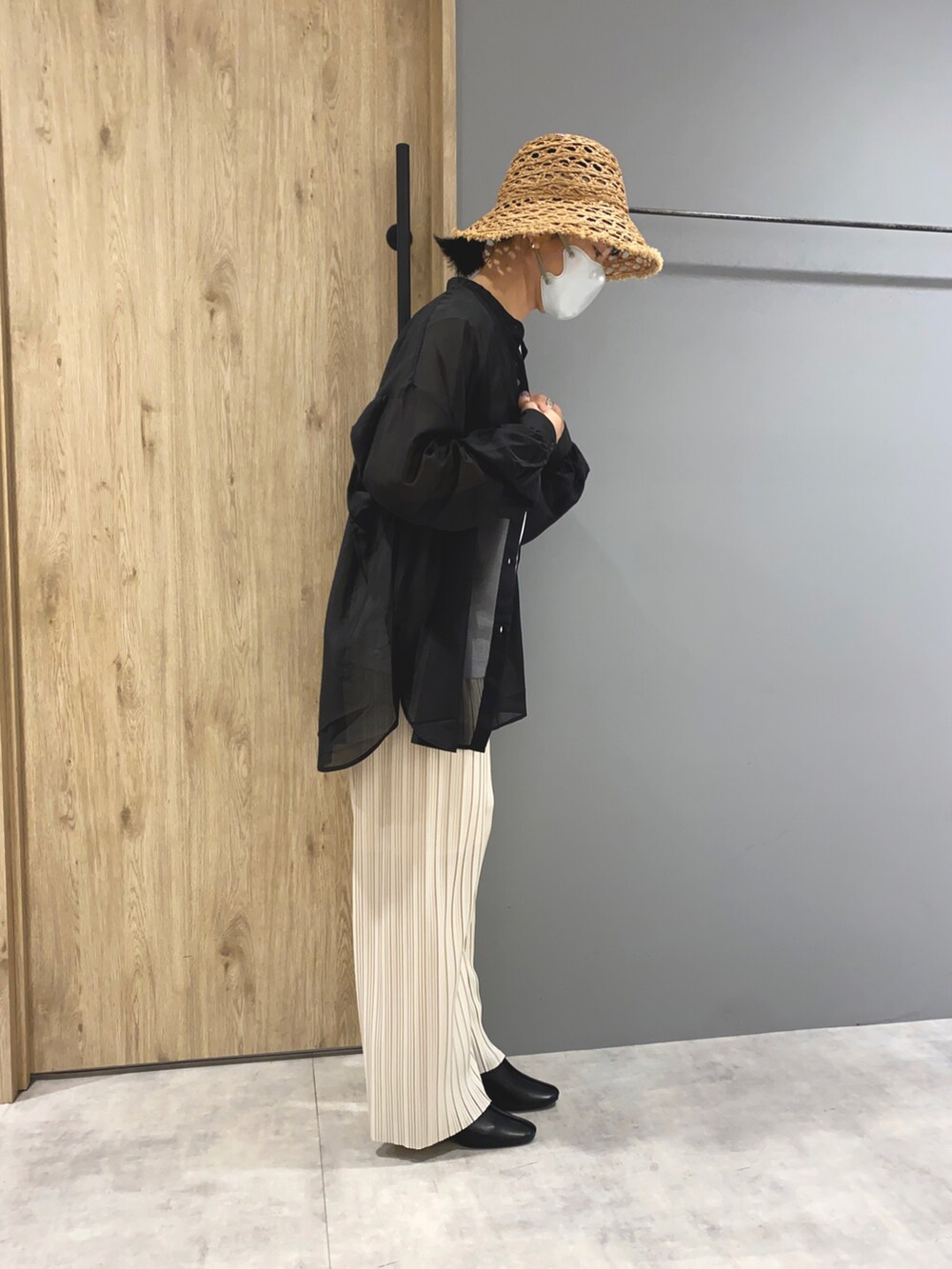 ホワイト系のTシャツ/カットソー、ブラック系のシャツ/ブラウス、ホワイト系のパンツを着用したレディースの春コーディネートの2枚目の写真