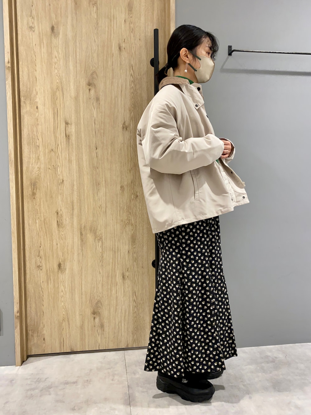 グリーン系のスウェット、ホワイト系のジャケット/アウター、ブラック系のスカートを着用したレディースの冬コーディネートの2枚目の写真