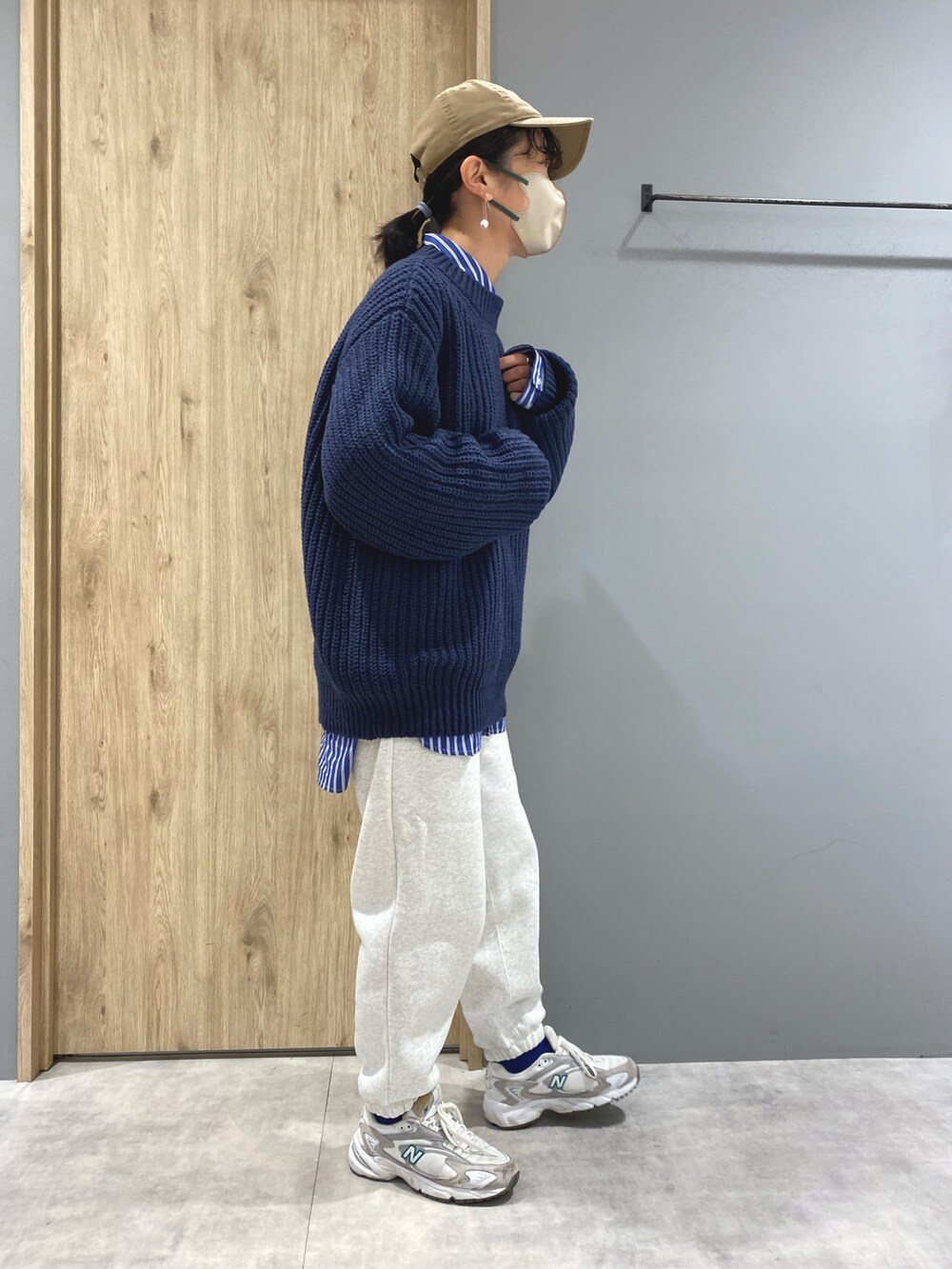 ブルー系のニット/セーター、ブルー系のシャツ/ブラウス、ホワイト系のスウェットパンツを着用したレディースの冬コーディネートの2枚目の写真