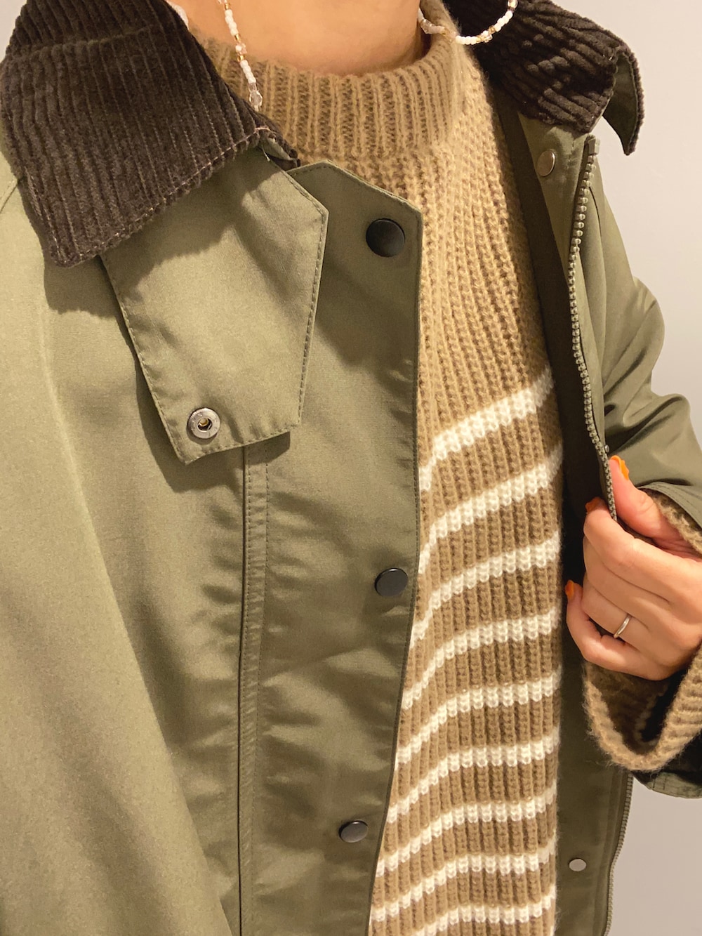 ベージュ系のニット/セーター、グリーン系のジャケット/アウター、ブラック系のブーツを着用したレディースの秋コーディネートの4枚目の写真