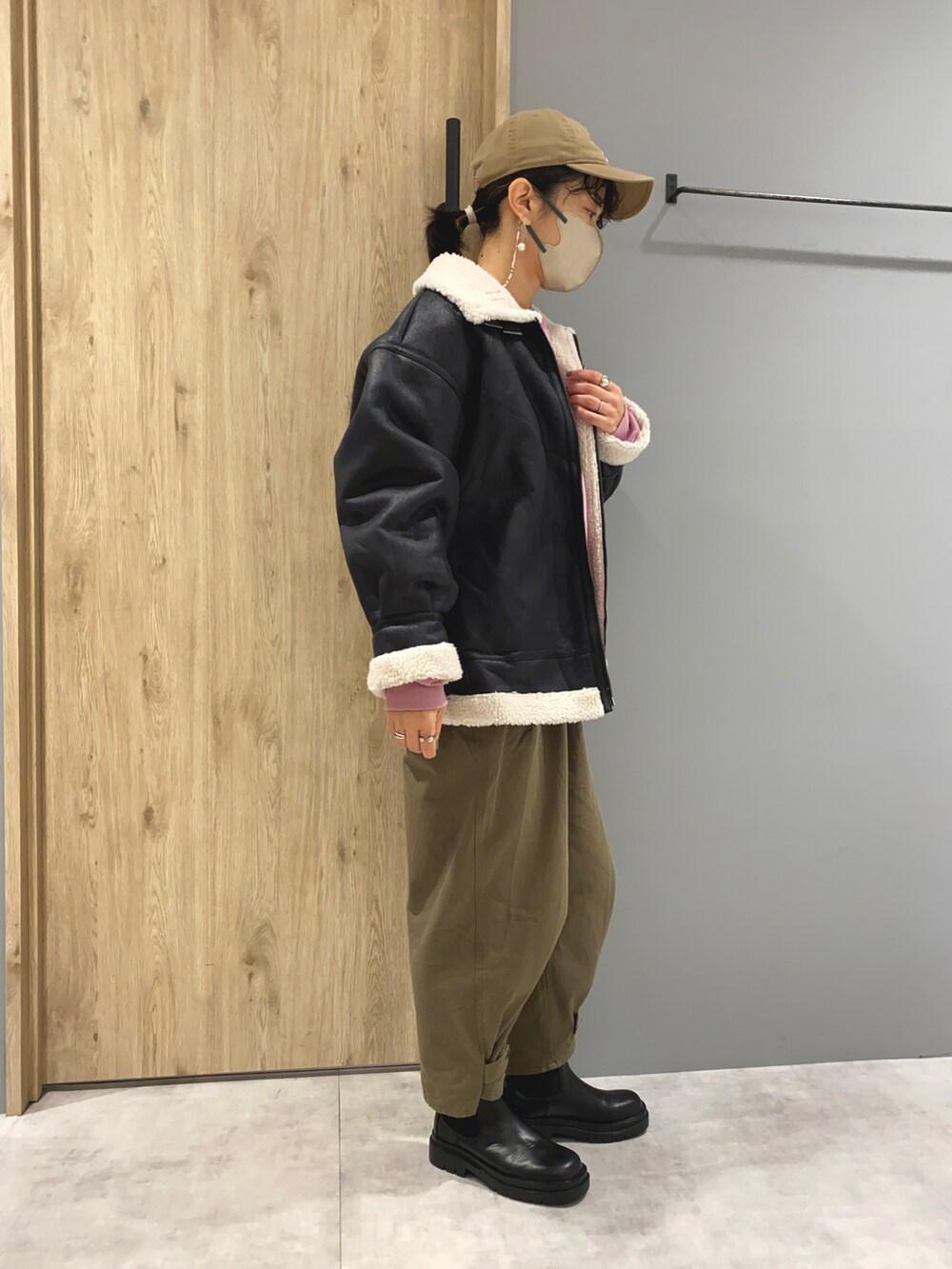 ピンク系のスウェット、ブラック系のジャケット/アウター、グリーン系のパンツを着用したレディースの冬コーディネートの2枚目の写真