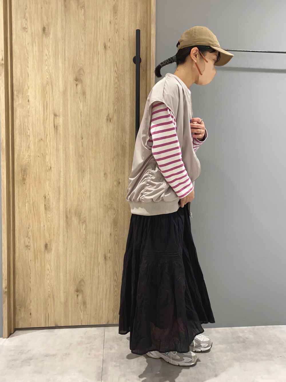 ピンク系のTシャツ/カットソー、グレー系のその他アウター、ブラック系のスカートを着用したレディースの春コーディネートの2枚目の写真