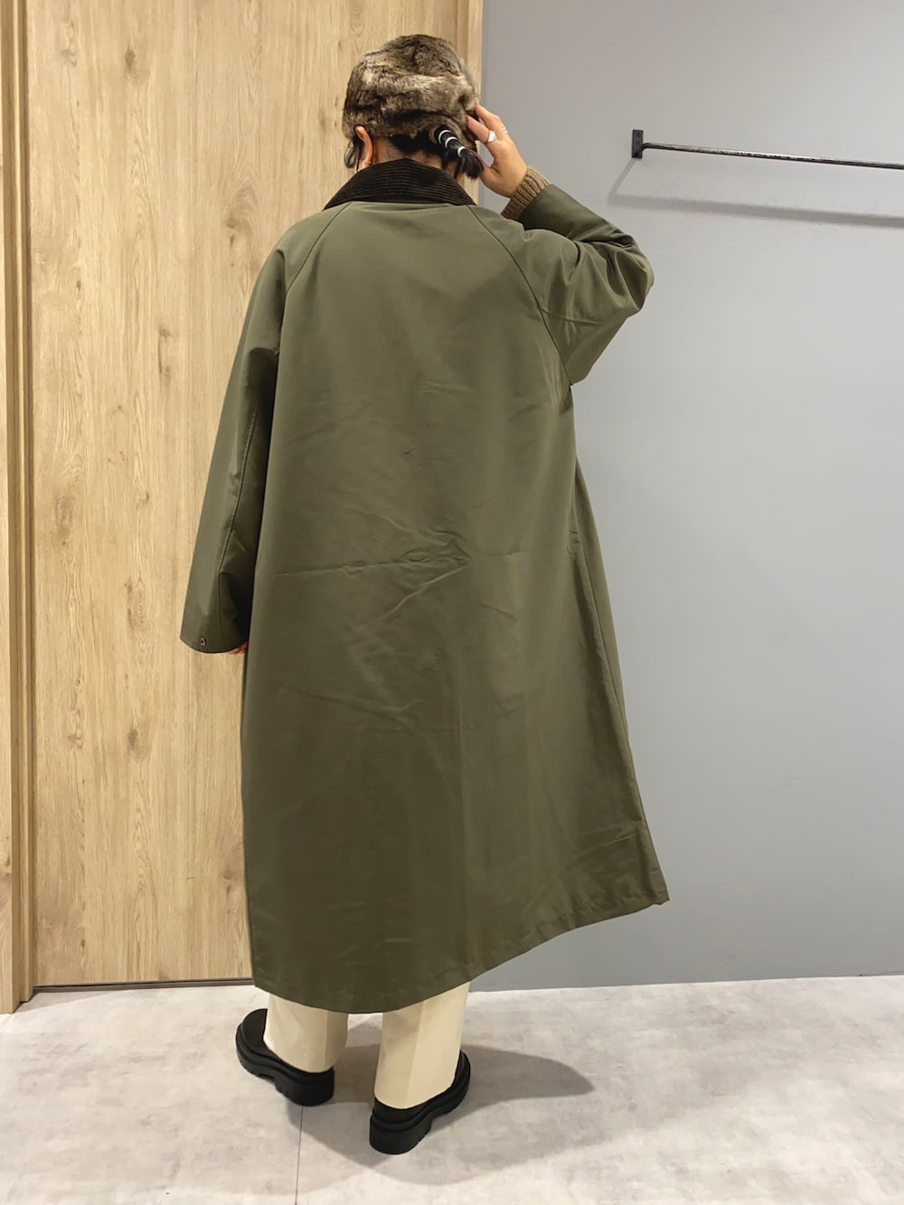 ベージュ系のニット/セーター、グリーン系のジャケット/アウター、ブラック系のブーツを着用したレディースの秋コーディネートの3枚目の写真