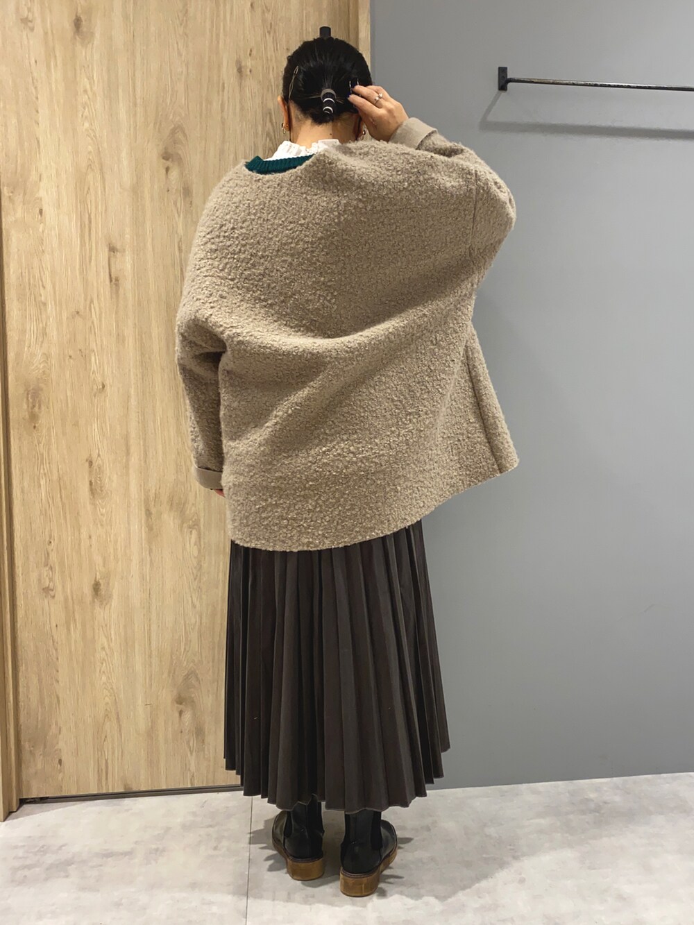 グリーン系のニット/セーター、ベージュ系のジャケット/アウター、グレー系のスカートを着用したレディースの秋コーディネートの3枚目の写真