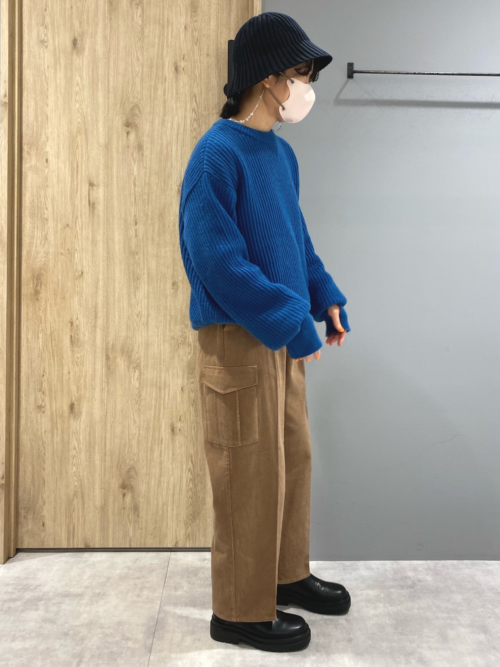 ブルー系のニット/セーター、ブラウン系のパンツ、ブラック系のブーツを着用したレディースの秋コーディネートの3枚目の写真