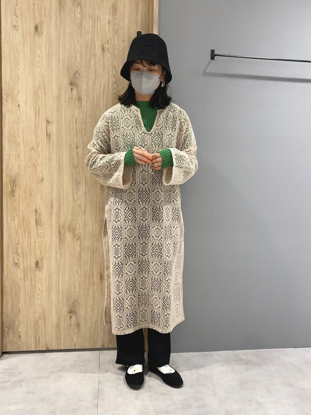 ベージュ系のワンピース、グリーン系のニット/セーター、ブラック系のシューズを着用したレディースの春コーディネートの2枚目の写真