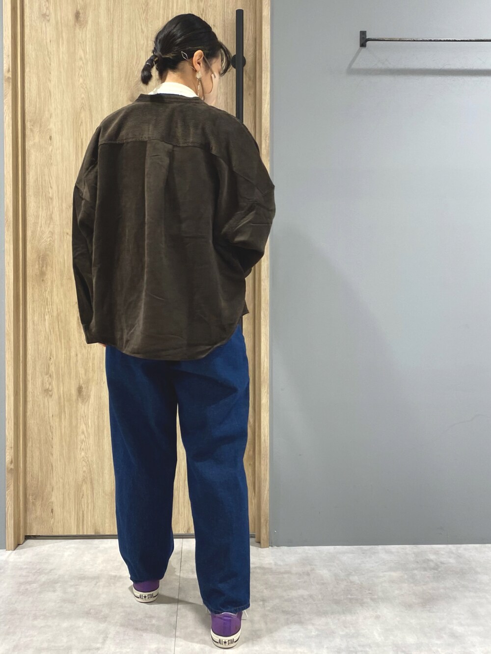 ブルー系のデニムパンツ、パープル系のスニーカー、ホワイト系のニット/セーターを着用したレディースの秋コーディネートの3枚目の写真