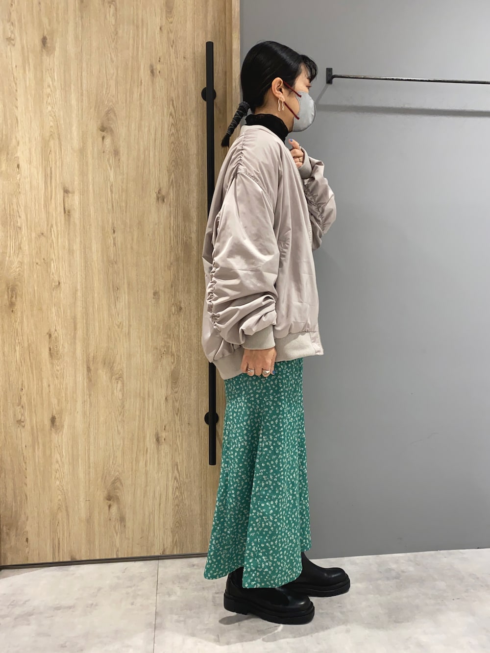 グレー系のスウェット、グレー系のブルゾン、グリーン系のスカートを着用したレディースの春コーディネートの2枚目の写真