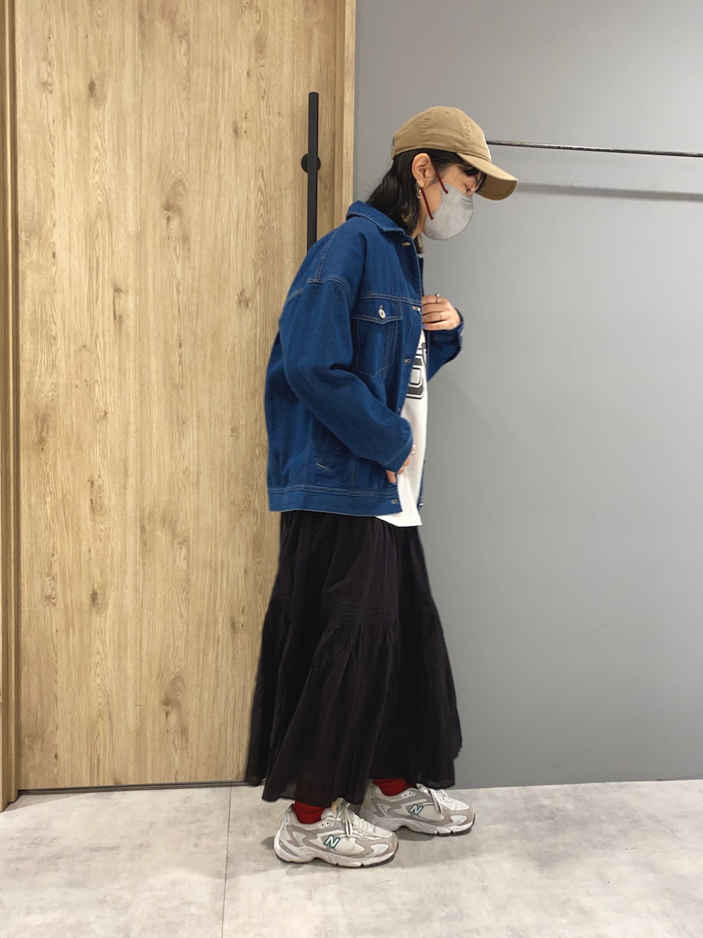 ブラック系のTシャツ/カットソー、ブルー系のデニムジャケット、ブラック系のスカートを着用したレディースの春コーディネートの2枚目の写真