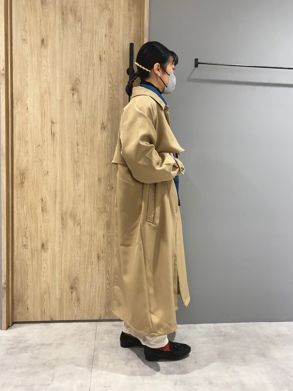 ブルー系のデニムジャケット、ベージュ系のトレンチコート、ホワイト系のその他パンツを着用したレディースの冬コーディネートの2枚目の写真