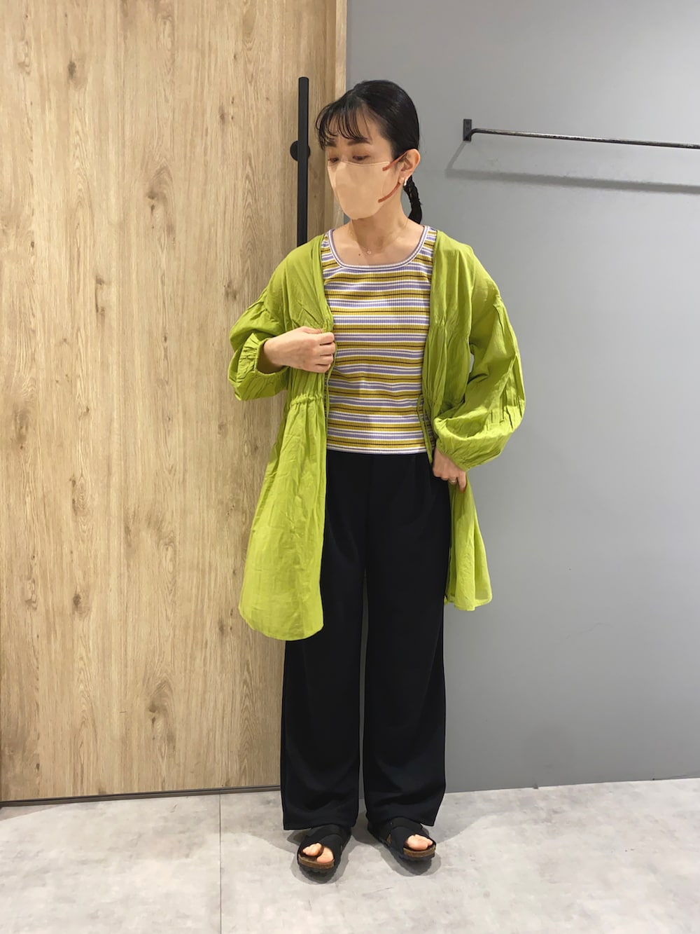ブラック系のパンツ、グリーン系のシャツ/ブラウス、ベージュ系のタンクトップを着用したレディースの春コーディネートの4枚目の写真