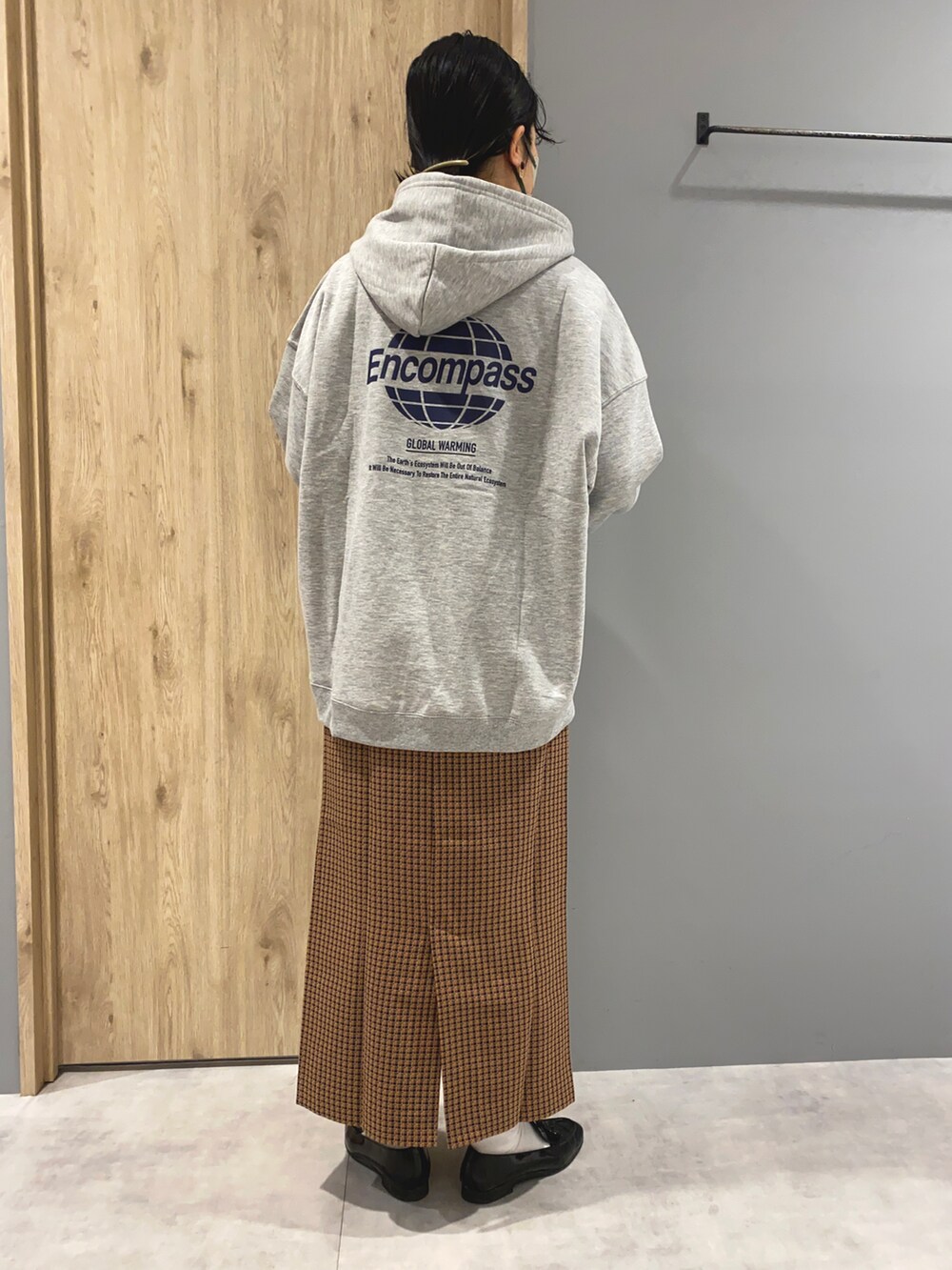 グレー系のパーカー、ブラウン系のスカート、ブラック系のローファーを着用したレディースの冬コーディネートの3枚目の写真