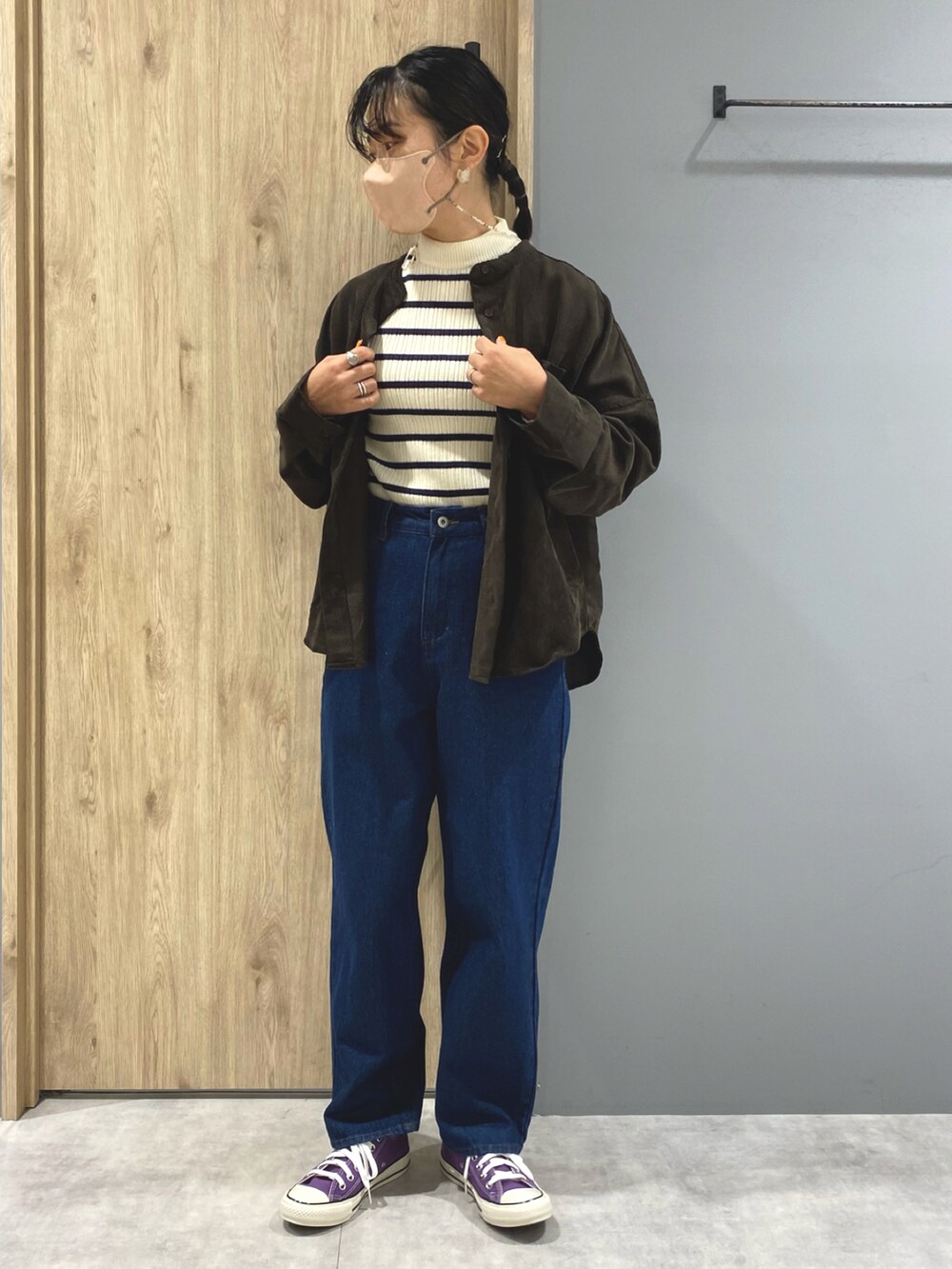 ブルー系のデニムパンツ、パープル系のスニーカー、ホワイト系のニット/セーターを着用したレディースの秋コーディネートの4枚目の写真