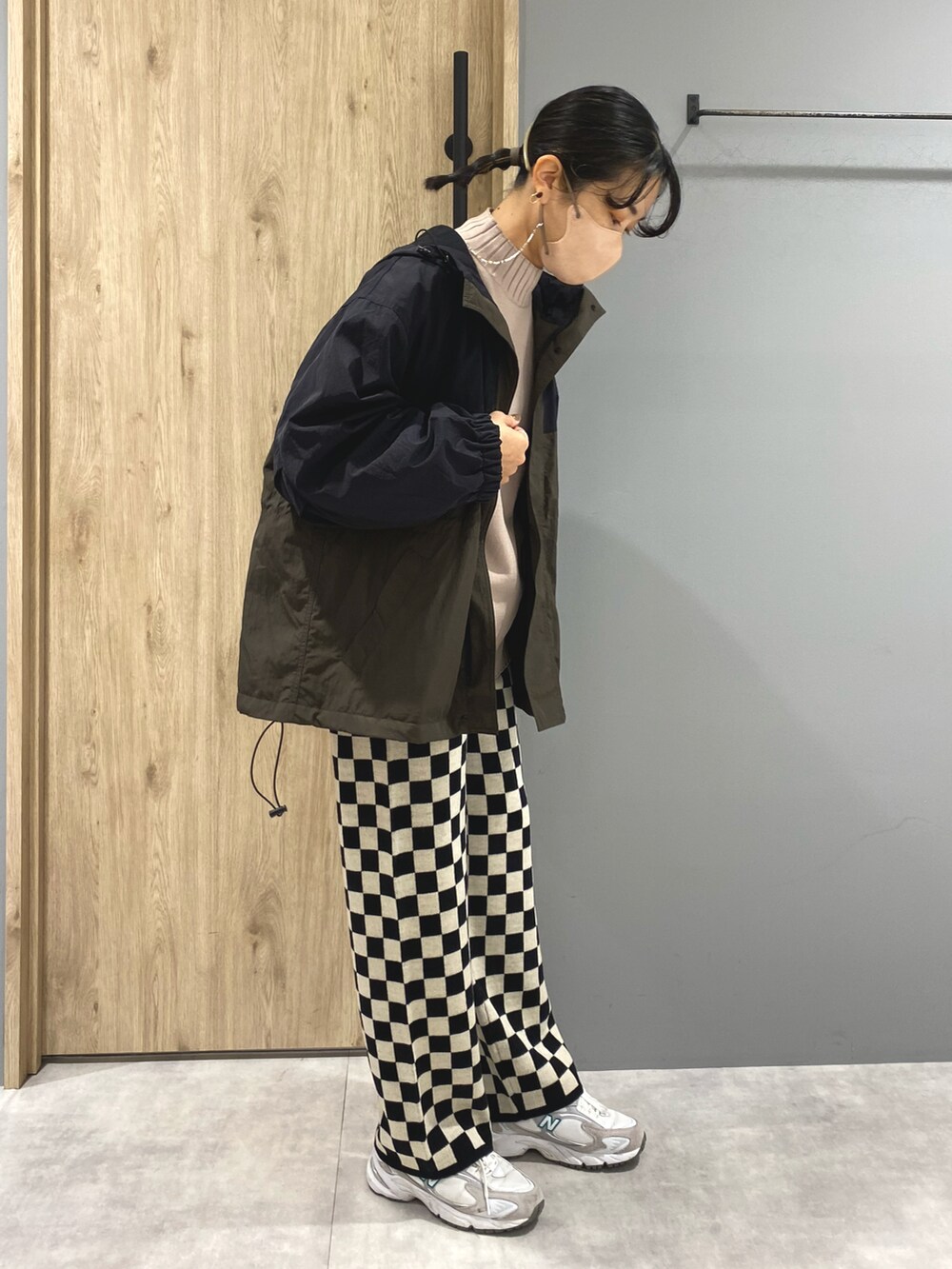 グリーン系のマウンテンパーカー、ベージュ系のニット/セーター、ブラック系のパンツを着用したレディースの秋コーディネートの2枚目の写真