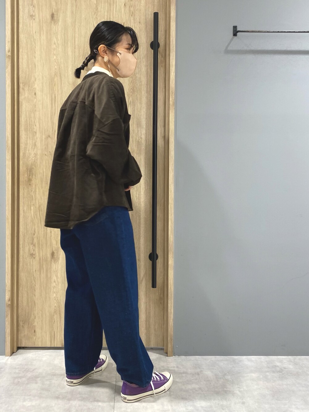 ブルー系のデニムパンツ、パープル系のスニーカー、ホワイト系のニット/セーターを着用したレディースの秋コーディネートの2枚目の写真