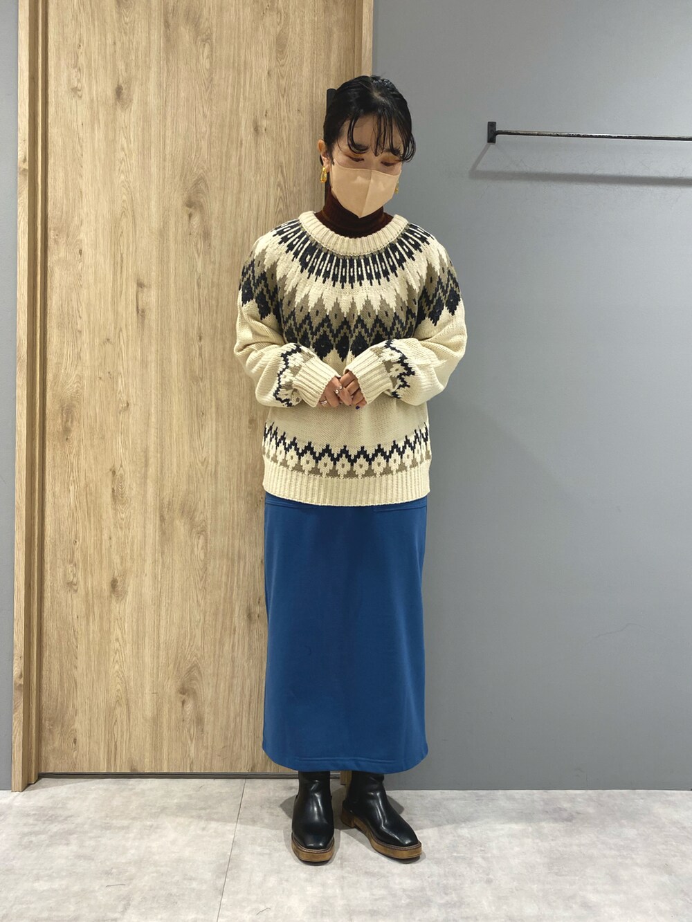 ホワイト系のニット/セーター、ブラック系のジャケット/アウター、ブルー系のスカートを着用したレディースの秋コーディネートの4枚目の写真