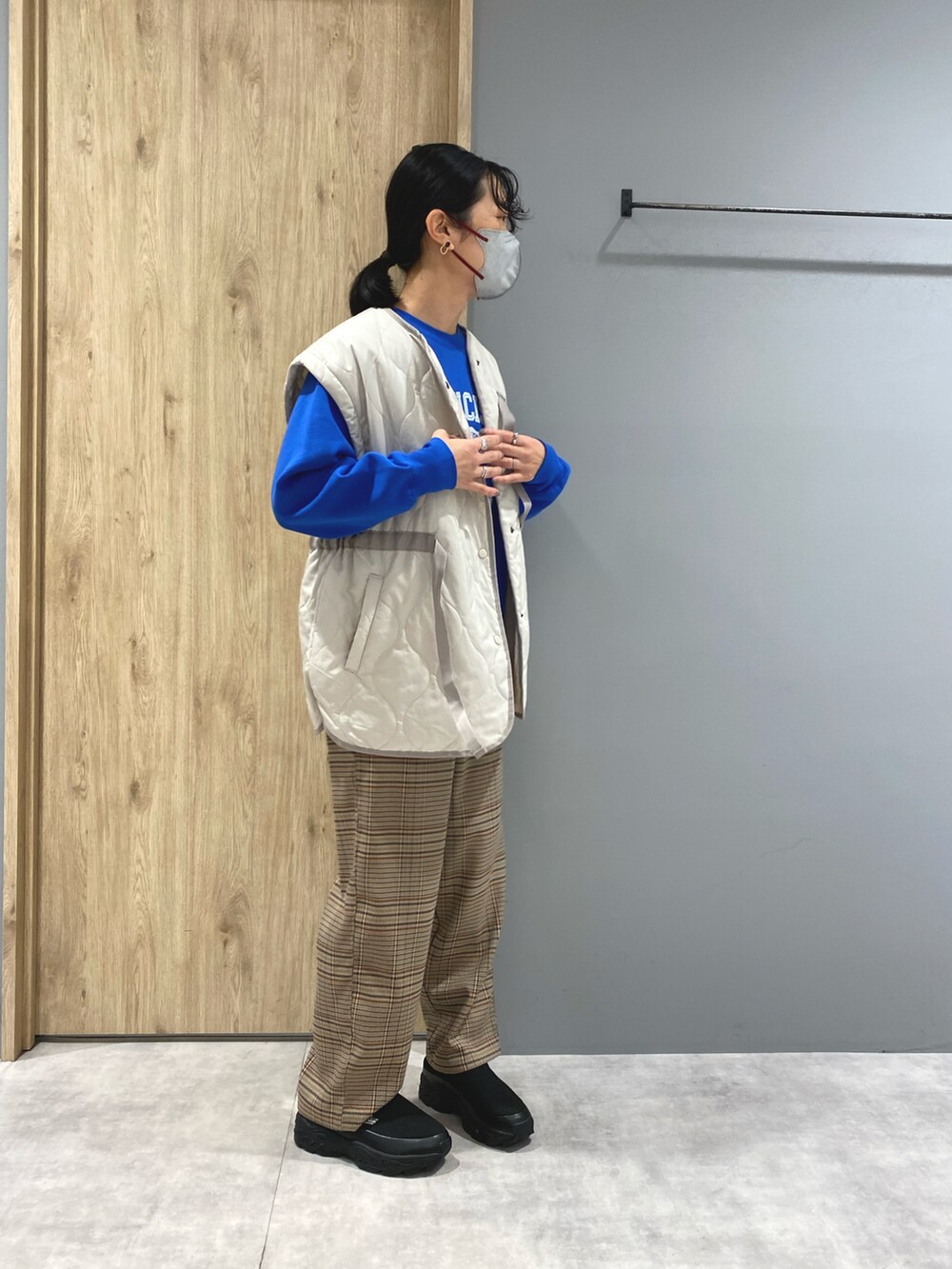 ブルー系のスウェット、ホワイト系のジャケット/アウター、ブラウン系のパンツを着用したレディースの冬コーディネートの2枚目の写真