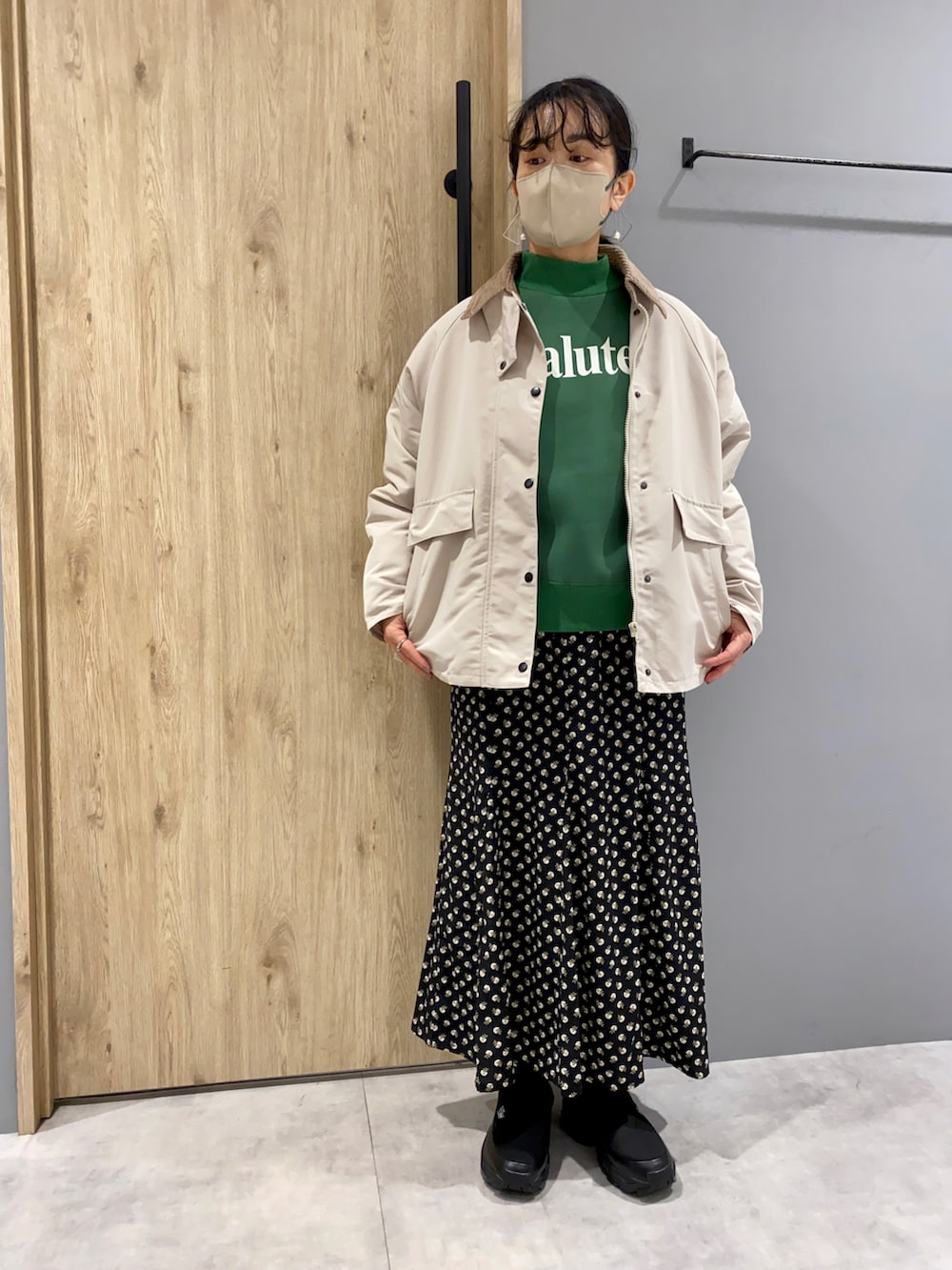 グリーン系のスウェット、ホワイト系のジャケット/アウター、ブラック系のスカートを着用したレディースの冬コーディネートの4枚目の写真