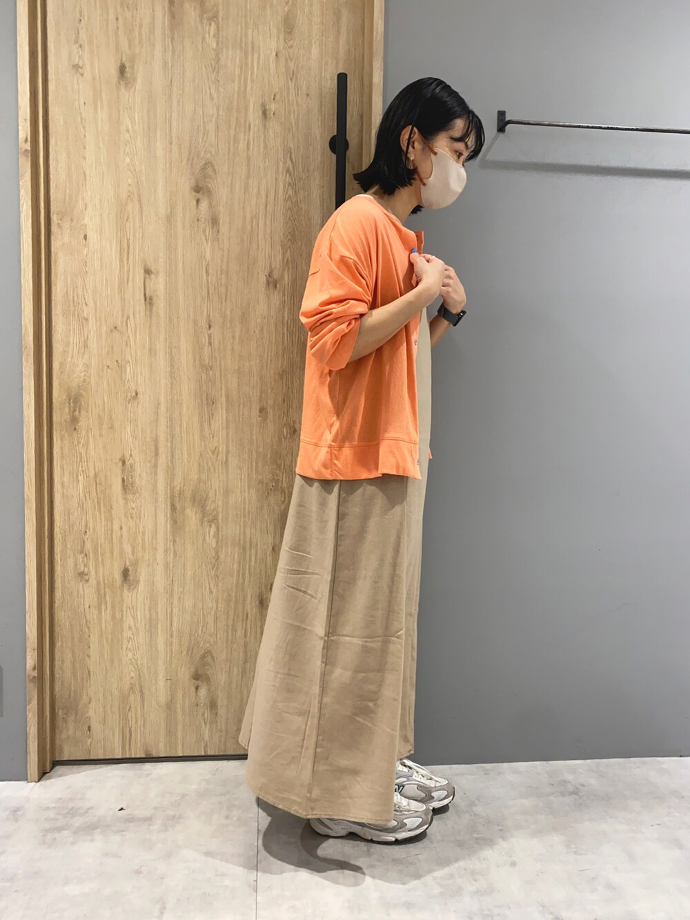 ベージュ系のワンピース、オレンジ系のカーディガン/ボレロ、ホワイト系のTシャツ/カットソーを着用したレディースの春コーディネートの2枚目の写真