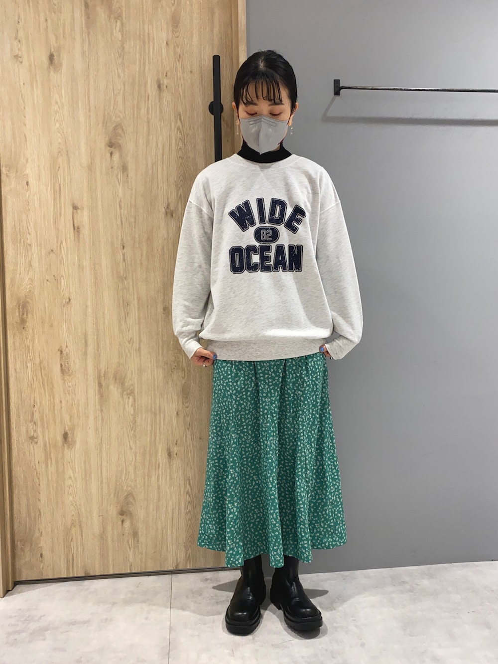 グレー系のスウェット、グレー系のブルゾン、グリーン系のスカートを着用したレディースの春コーディネートの5枚目の写真