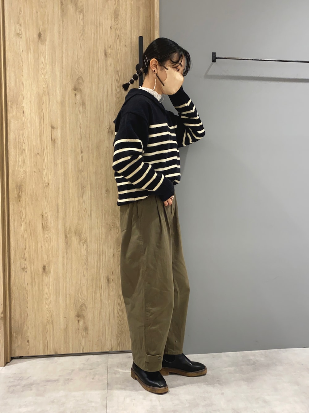 ホワイト系のシャツ/ブラウス、ブラック系のニット/セーター、グリーン系のパンツを着用したレディースの秋コーディネートの2枚目の写真