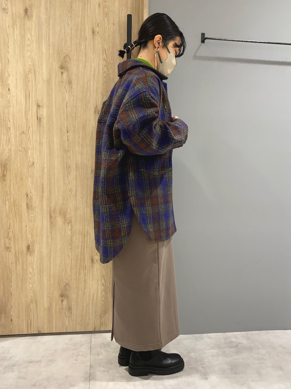 グリーン系のニット/セーター、ブルー系のジャケット/アウター、ベージュ系のスカートを着用したレディースの秋コーディネートの3枚目の写真