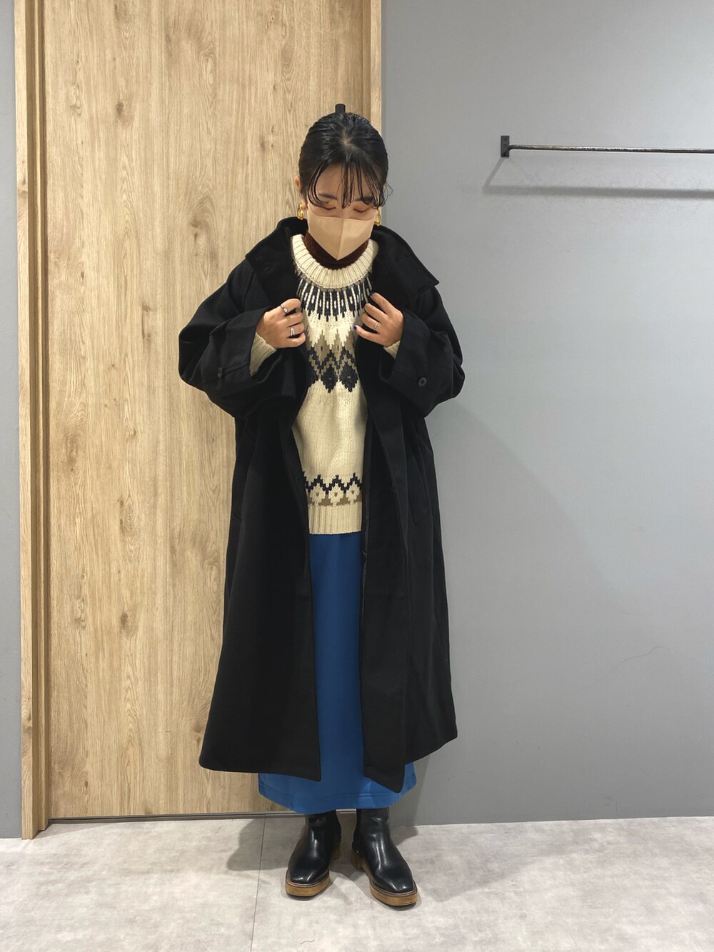 ホワイト系のニット/セーター、ブラック系のジャケット/アウター、ブルー系のスカートを着用したレディースの秋コーディネートの2枚目の写真