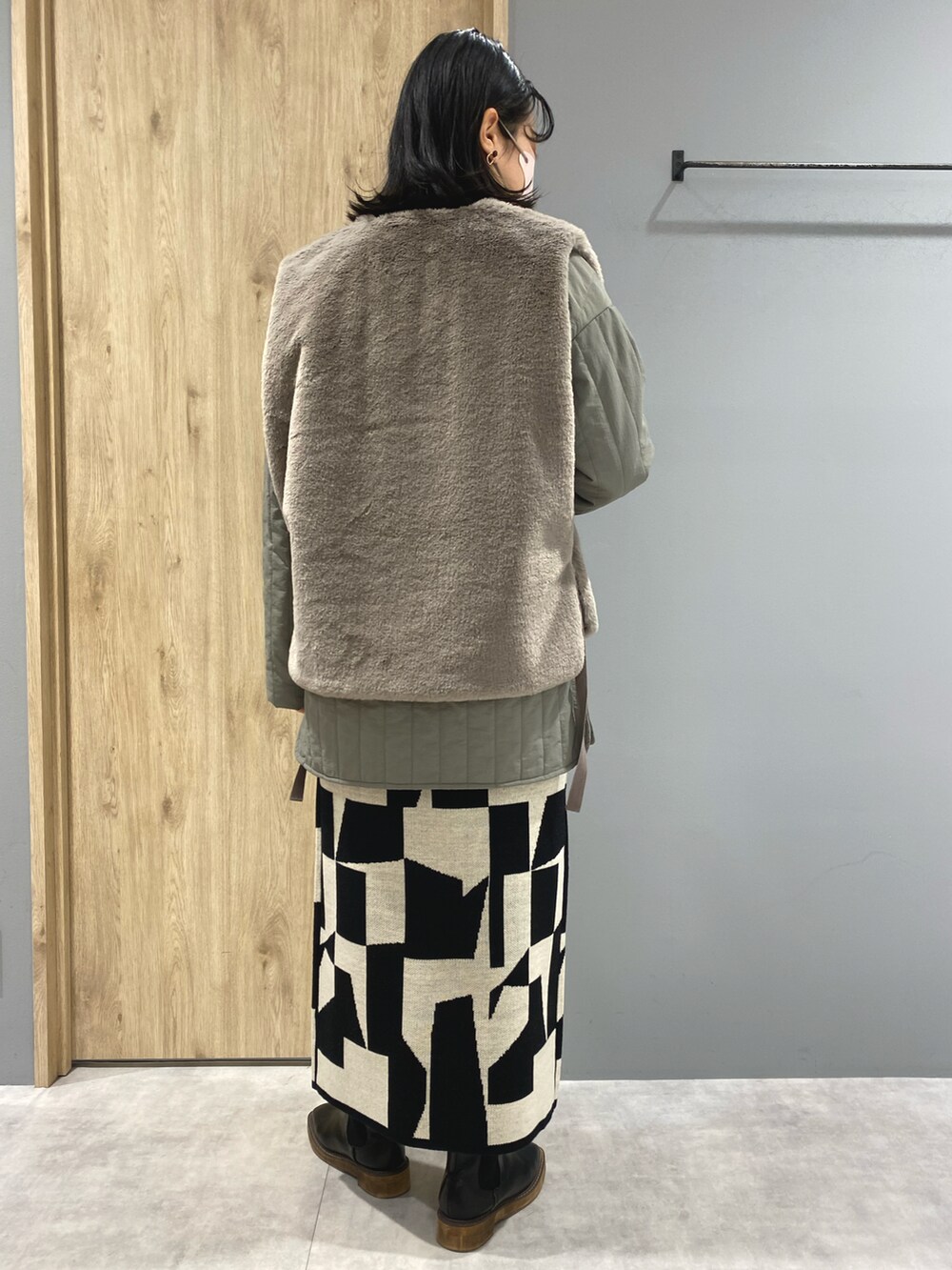 グリーン系のジャケット/アウター、ブラック系のニット/セーター、ブラック系のスカートを着用したレディースの秋コーディネートの3枚目の写真