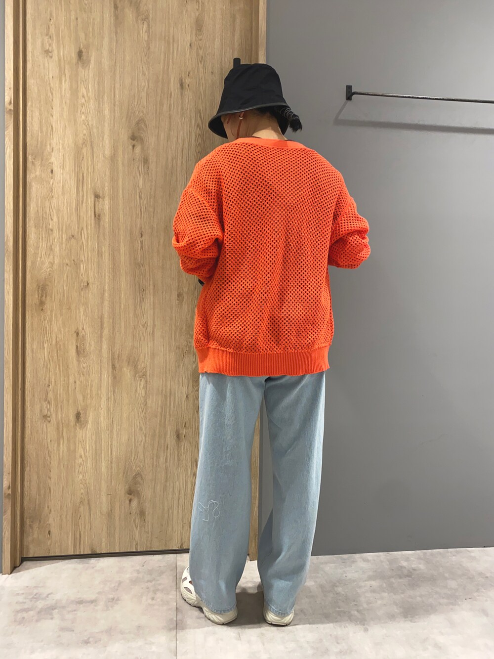 ブラウン系のTシャツ/カットソー、オレンジ系のカーディガン/ボレロ、ブルー系のデニムパンツを着用したレディースの春コーディネートの3枚目の写真