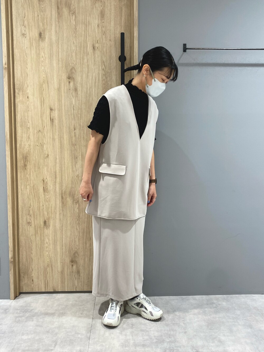 ホワイト系のスニーカー、ホワイト系のスカート、ホワイト系のベストを着用したレディースの春コーディネートの2枚目の写真