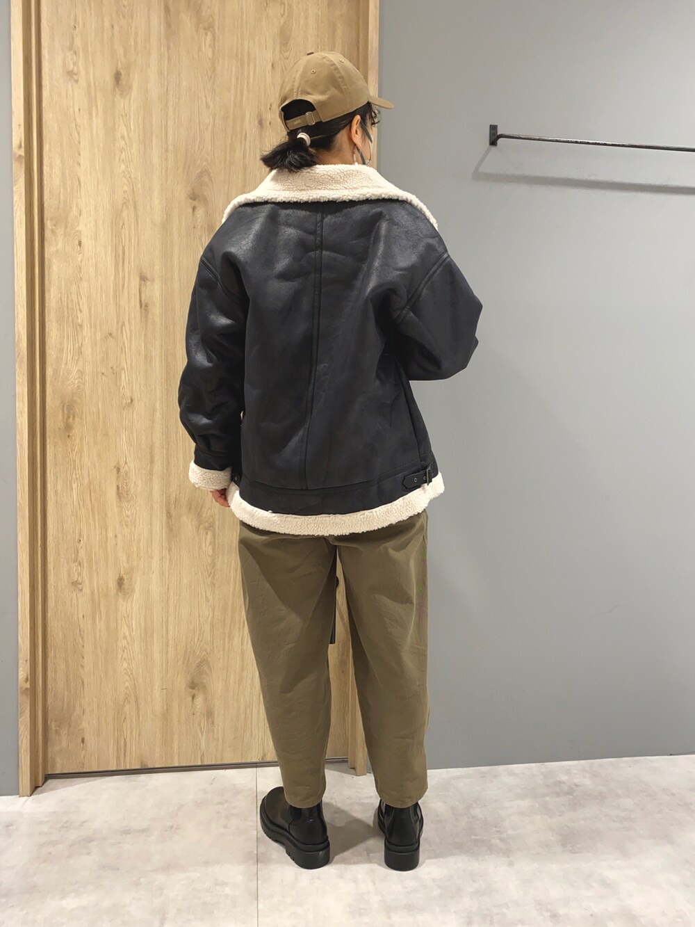 ピンク系のスウェット、ブラック系のジャケット/アウター、グリーン系のパンツを着用したレディースの冬コーディネートの3枚目の写真