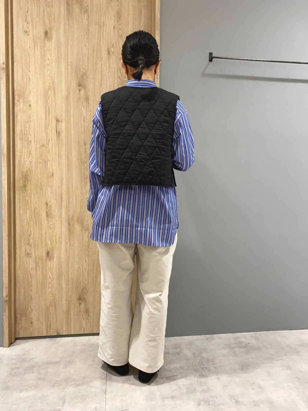 ブルー系のシャツ/ブラウス、ブラック系のベスト、ホワイト系のその他パンツを着用したレディースの冬コーディネートの3枚目の写真