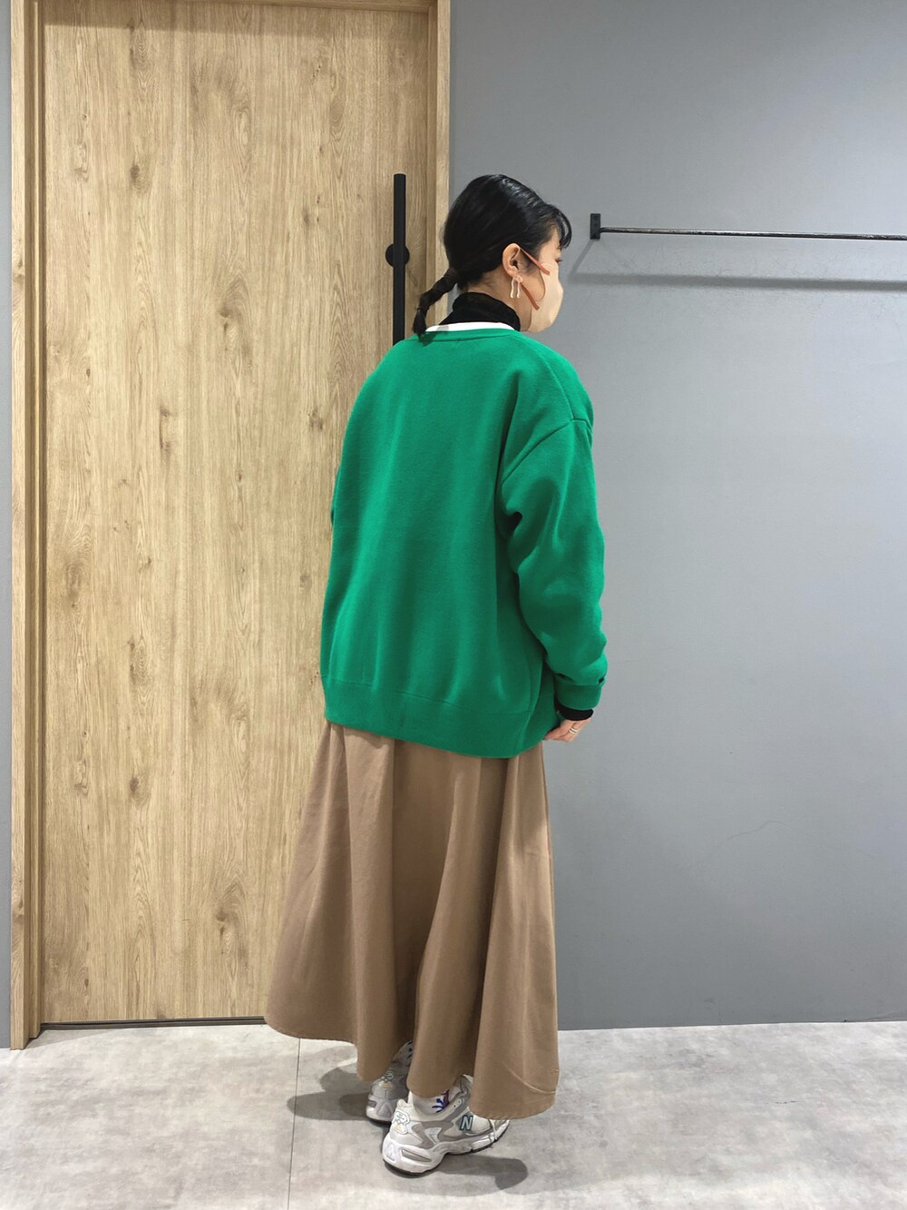 ホワイト系のTシャツ/カットソー、ブラック系のスカート、グリーン系のカーディガン/ボレロを着用したレディースの冬コーディネートの4枚目の写真