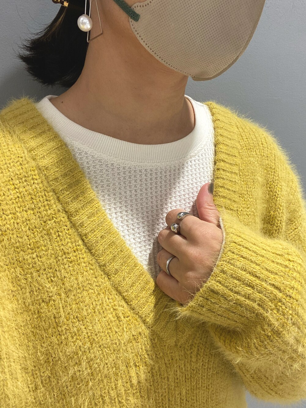 イエロー系のニット/セーター、ホワイト系のTシャツ/カットソー、ブラック系のパンツを着用したレディースの秋コーディネートの4枚目の写真