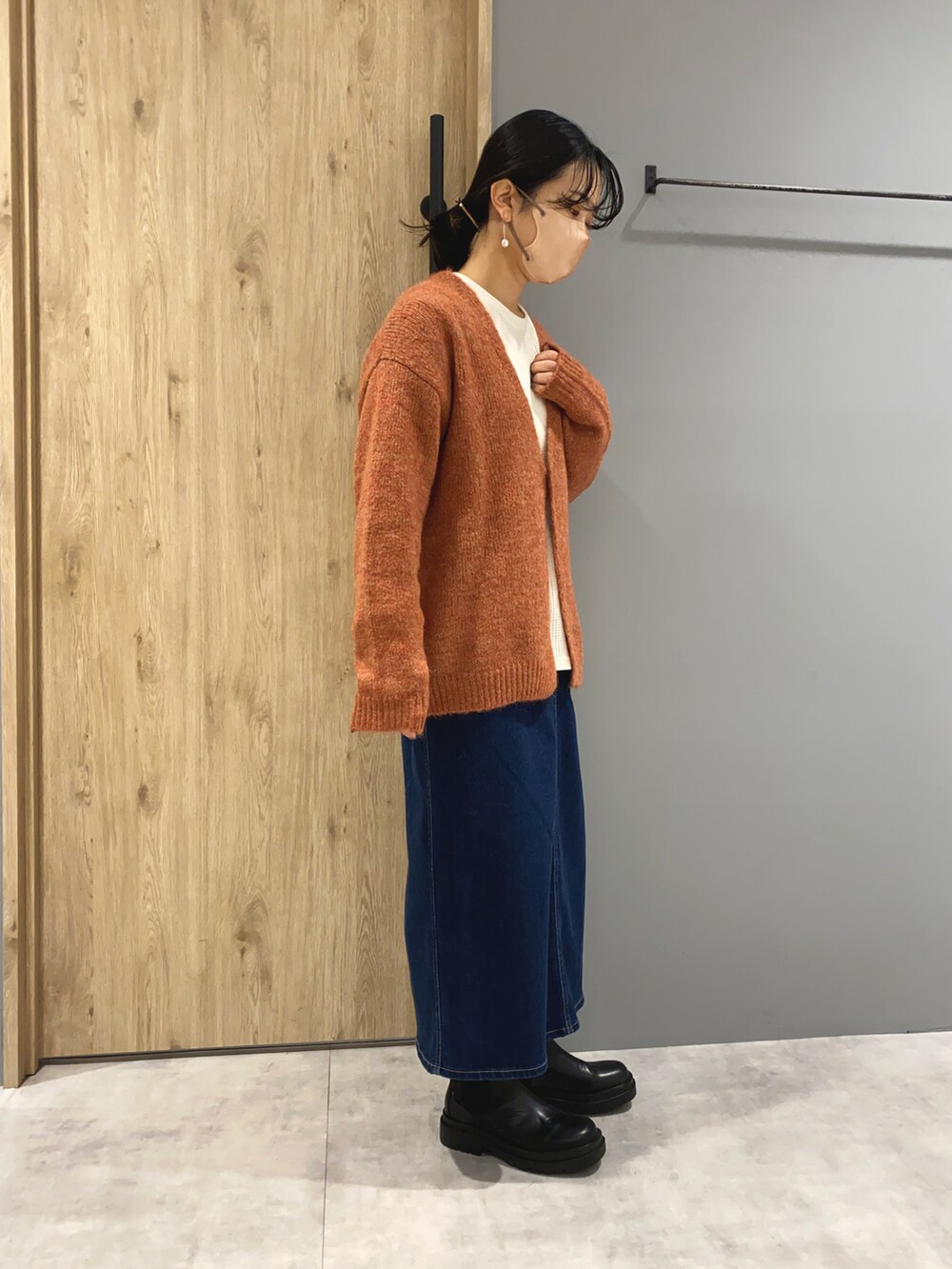 ブルー系のデニムスカート、ホワイト系のジャケット/アウター、オレンジ系のカーディガン/ボレロを着用したレディースの秋コーディネートの5枚目の写真