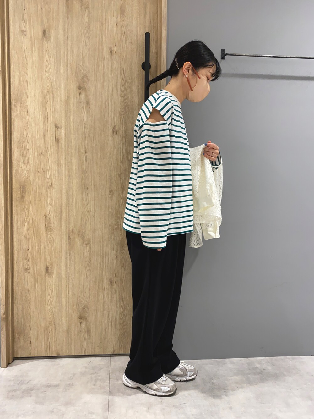 グリーン系のTシャツ/カットソー、ホワイト系のシャツ/ブラウス、ブラック系のパンツを着用したレディースの春コーディネートの4枚目の写真