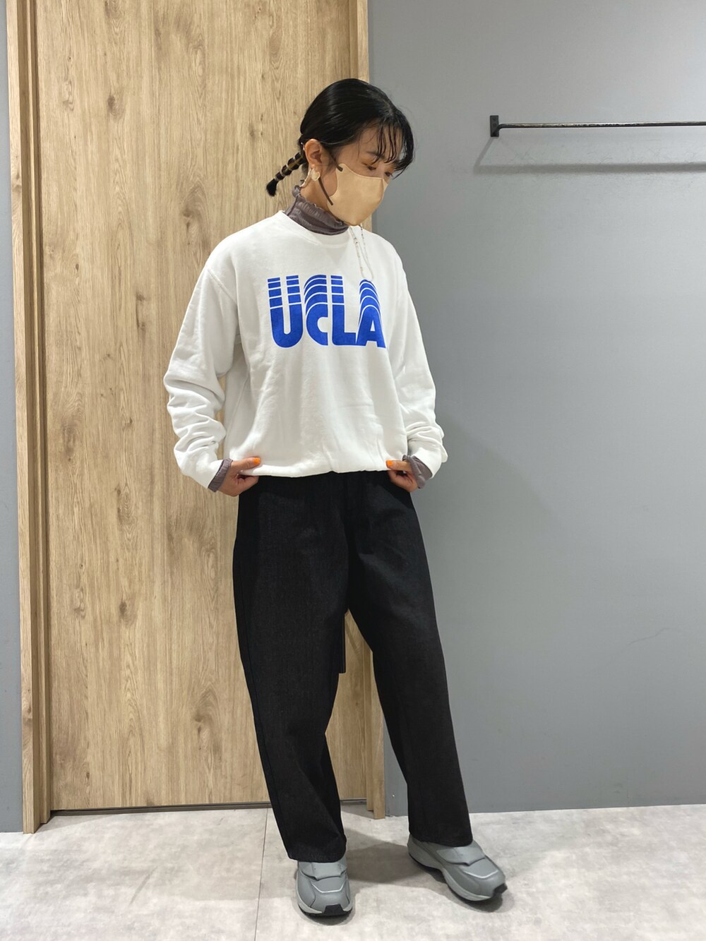 ブラック系のデニムパンツ、グレー系のスニーカー、ホワイト系のスウェットを着用したレディースの秋コーディネートの4枚目の写真