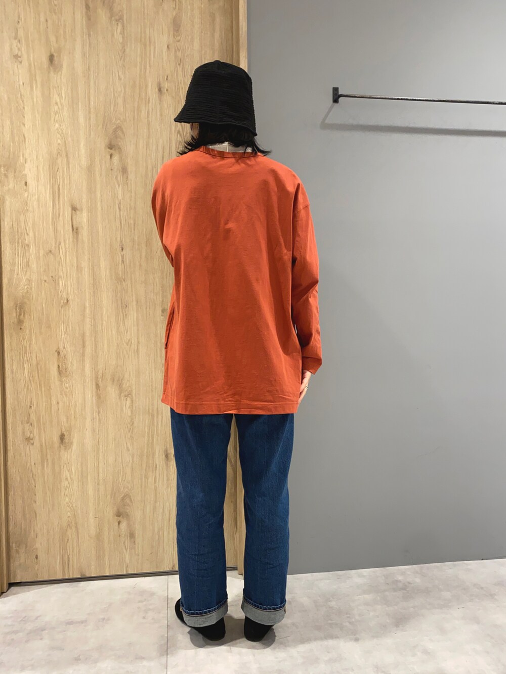 オレンジ系のカーディガン/ボレロ、ブルー系のデニムパンツ、ブラック系のシューズを着用したレディースの春コーディネートの3枚目の写真