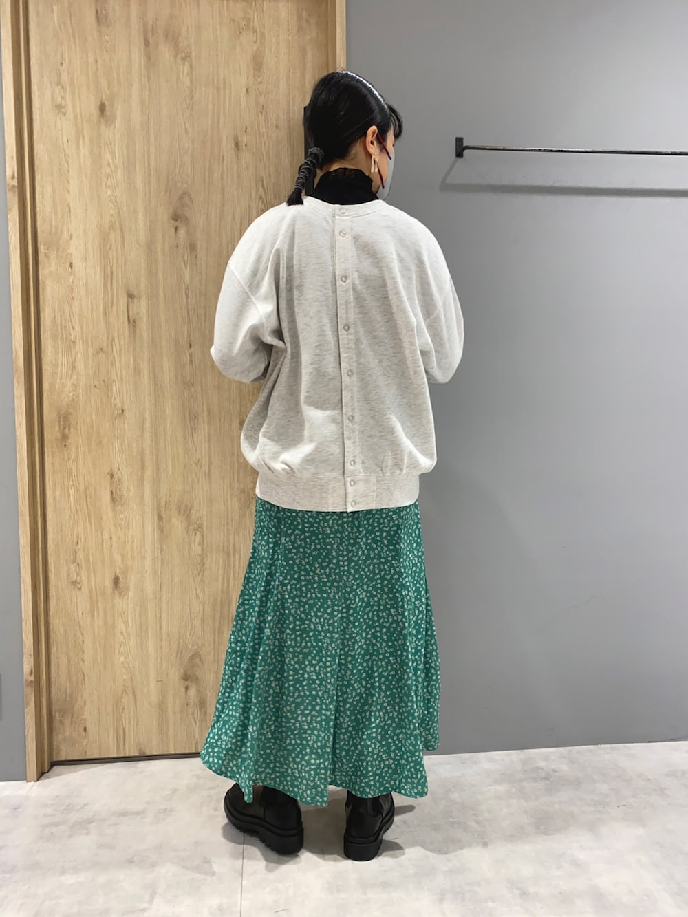 グレー系のスウェット、グレー系のブルゾン、グリーン系のスカートを着用したレディースの春コーディネートの4枚目の写真