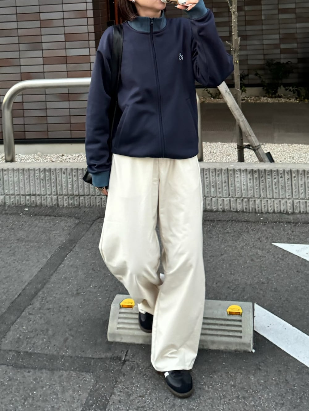 ブルー系のジャージ、ホワイト系のスラックス、ブラック系のスニーカーを着用したレディースの冬コーディネートの3枚目の写真