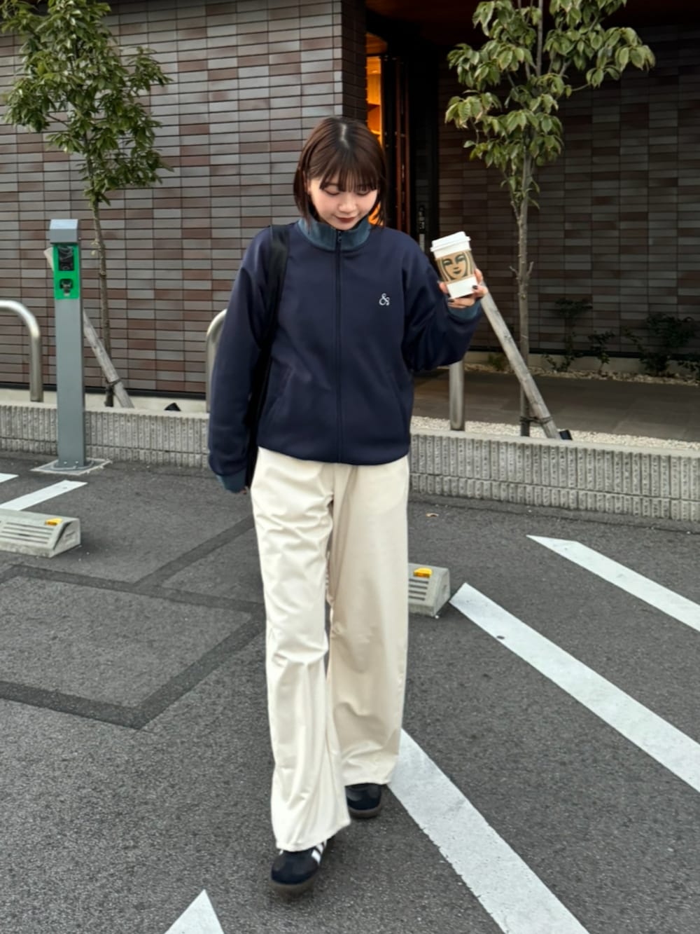 ブルー系のジャージ、ホワイト系のスラックス、ブラック系のスニーカーを着用したレディースの冬コーディネートの2枚目の写真