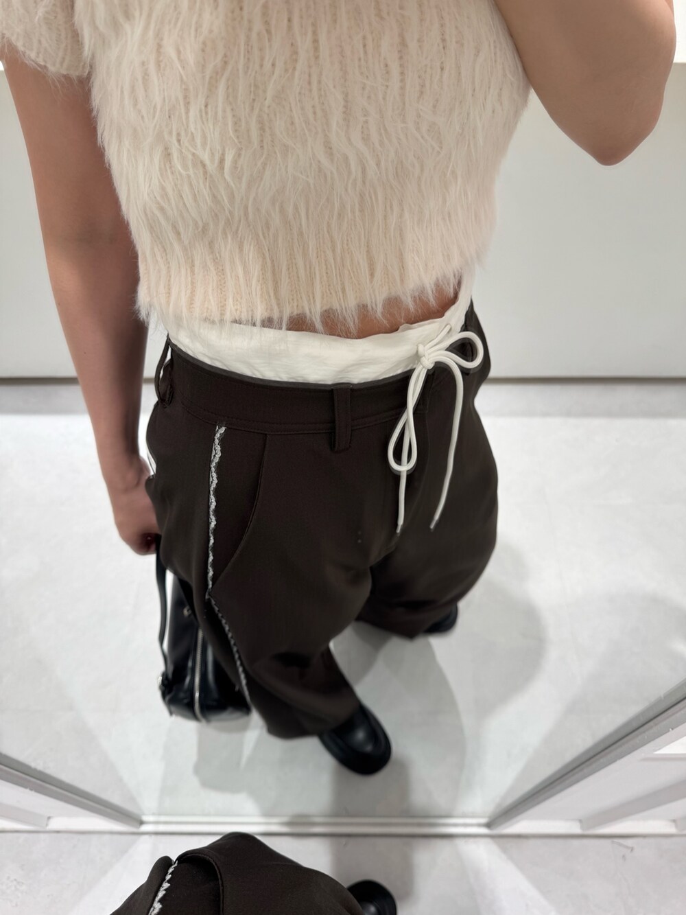 ピンク系のニット/セーター、ブラウン系のその他パンツ、ブラック系のボストンバッグを着用したレディースの秋コーディネートの3枚目の写真