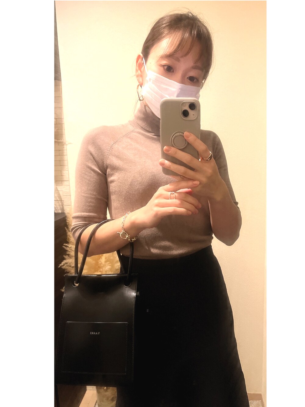 ブルー系のスカート、ベージュ系のニット/セーター、ブラック系のジャケット/アウターを着用したレディースの秋コーディネートの2枚目の写真