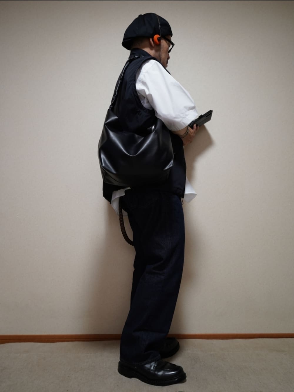 ブラック系のシューズ、ブルー系のデニムパンツ、ブラック系のショルダーバッグを着用したメンズの夏コーディネートの5枚目の写真