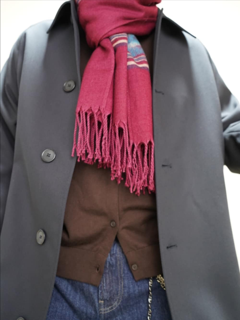 ブラック系のドレスシューズ、ブルー系のデニムパンツ、ブルー系のステンカラーコートを着用したメンズの春コーディネートの3枚目の写真