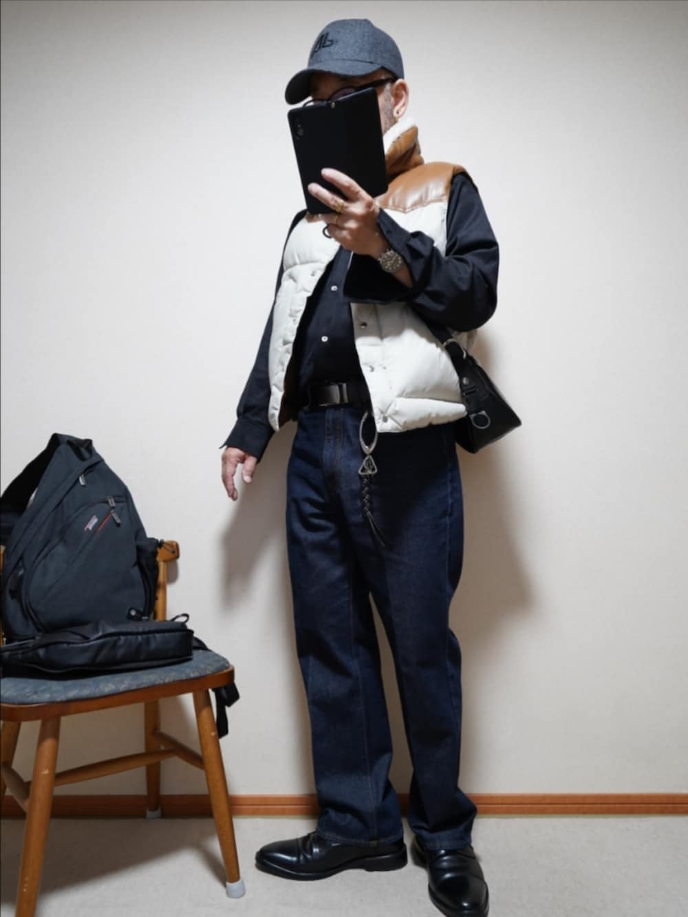 ブルー系のデニムパンツ、ブラック系のシャツ/ブラウス、その他のダウンベストを着用したメンズの秋コーディネートの2枚目の写真