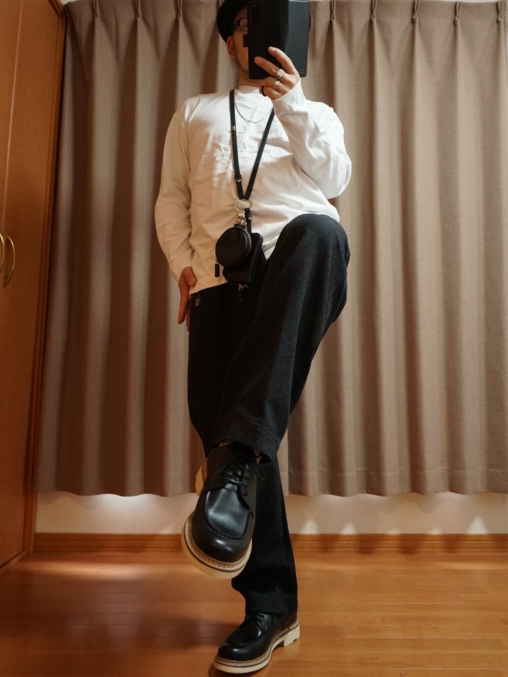 ブラック系のシューズ、グレー系のパンツ、ブラック系のショルダーバッグを着用したメンズの春コーディネートの3枚目の写真