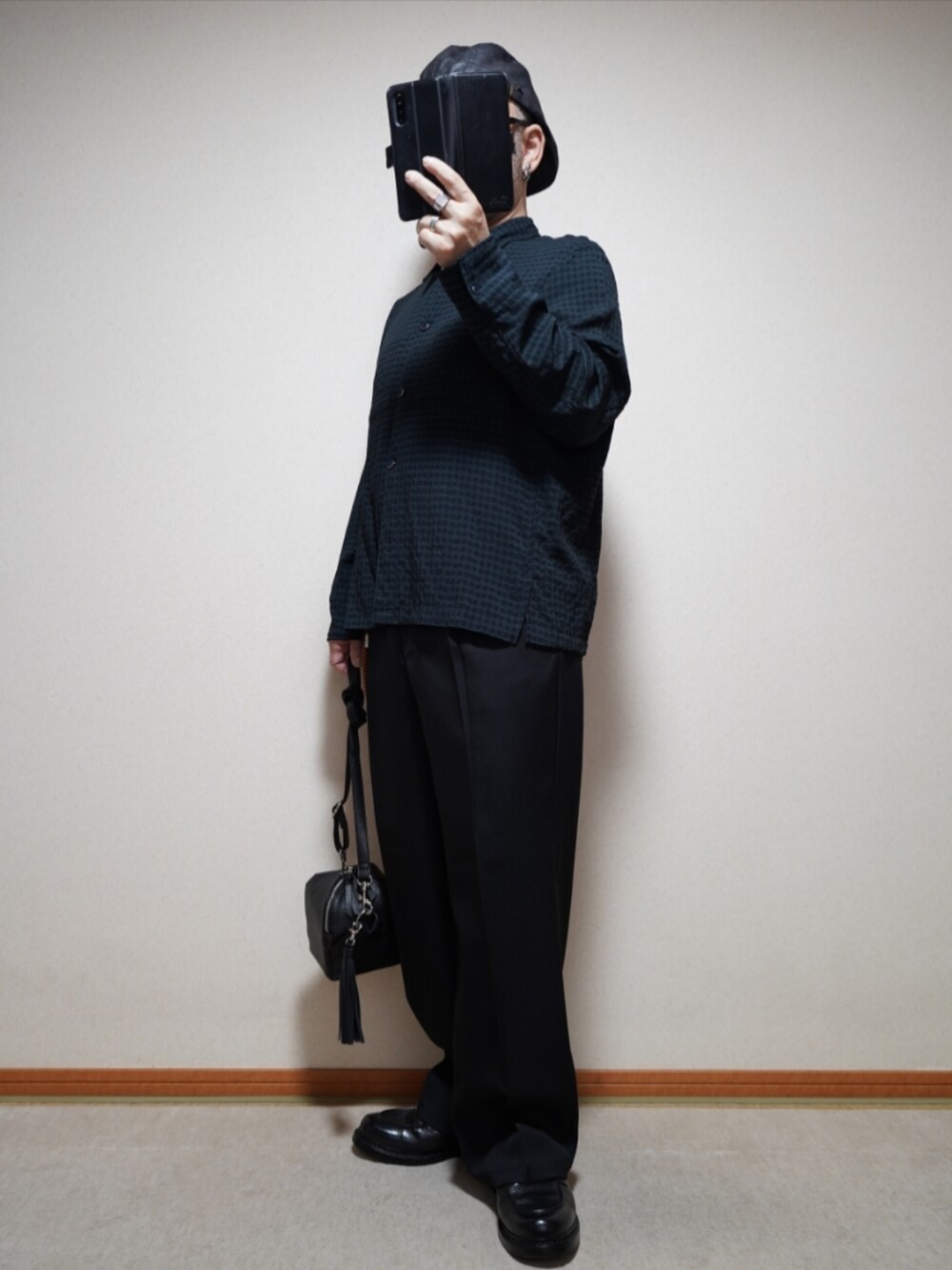 ブラック系のシューズ、ブラック系のパンツ、ブラック系のショルダーバッグを着用したメンズの春コーディネートの2枚目の写真