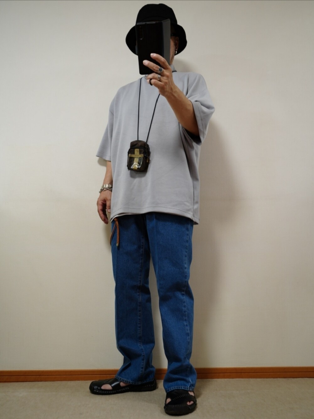 ブラック系のサンダル、ブルー系のデニムパンツ、ホワイト系のタンクトップを着用したメンズの夏コーディネートの2枚目の写真