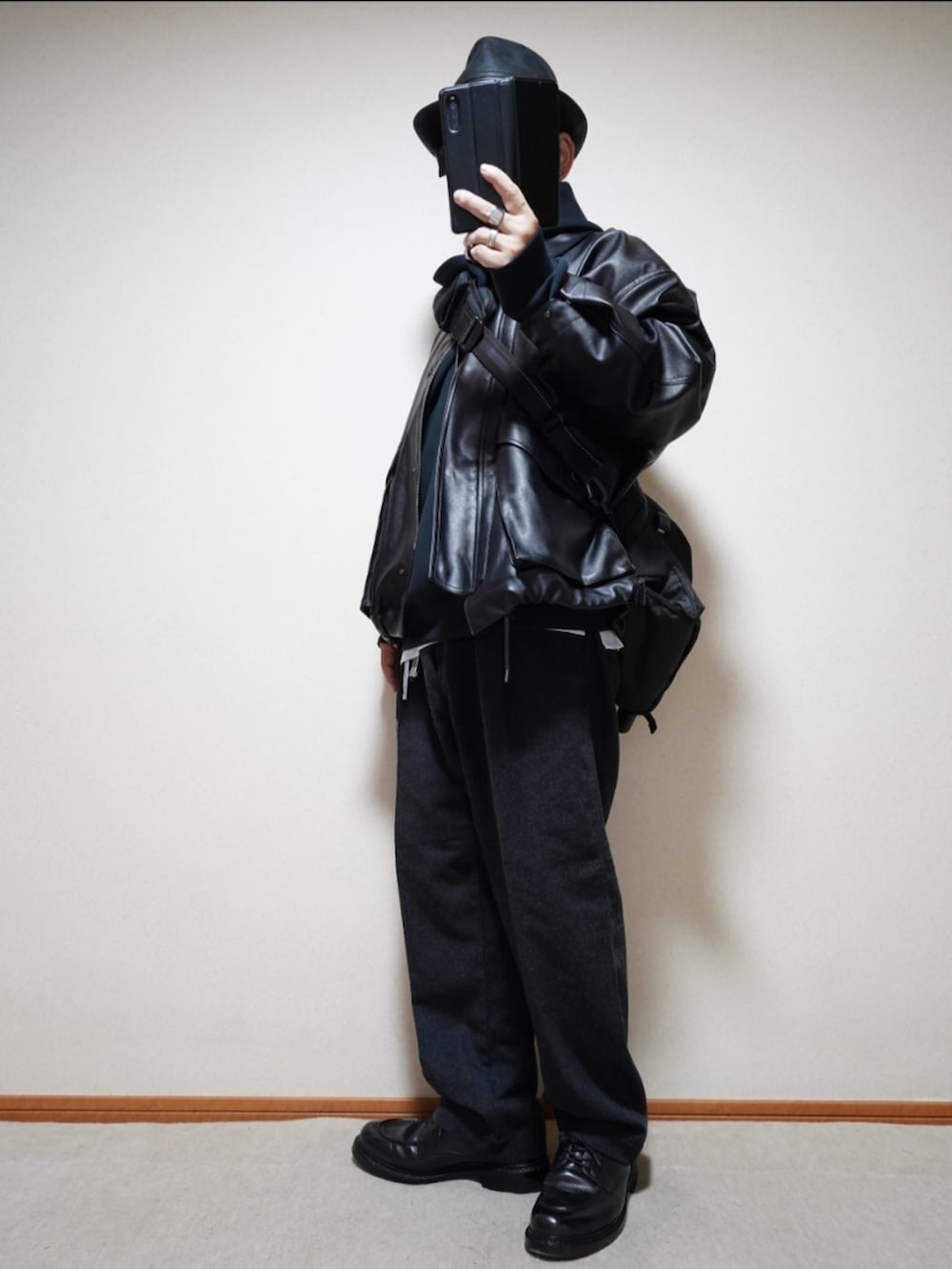 ブラック系のシューズ、グレー系のパンツ、ブラック系のパーカーを着用したメンズの秋コーディネートの2枚目の写真